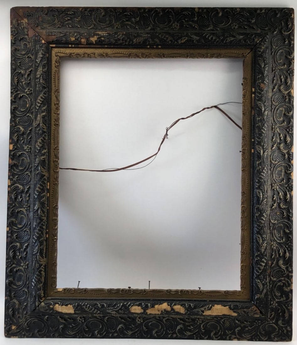 Ornate Gesso & Wood Picture Frame: Ornate picture frame featuring deep relief foliate and scroll motifs in a dark finish with a gold-tone inner liner. Constructed of molded gesso over wood. Shows heavy wear, craquelure, and