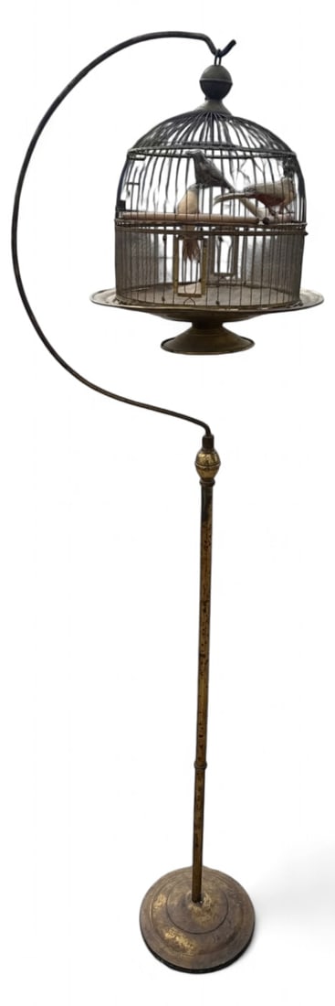 Brass Floor Birdcage with Faux Birds 64" H: Floor-standing brass birdcage featuring a domed wire cage suspended from a curved arm on a tiered round base. Includes several vintage-style faux birds perched inside. Unmarked. Measures 64" h.