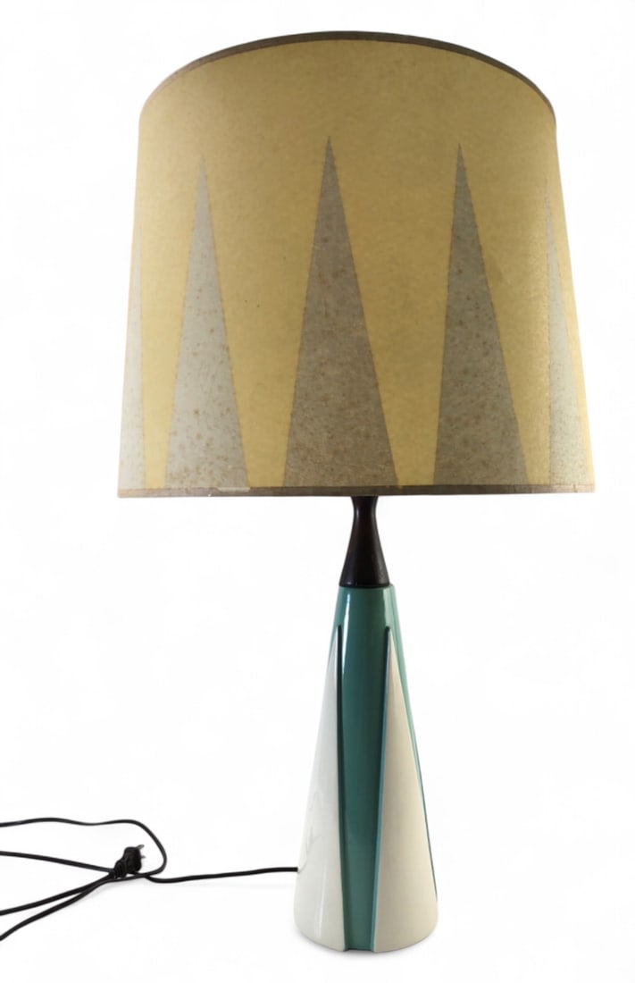 MCM Teal and White Ceramic Table Lamp with Rawhide Shade: Mid-Century Modern table lamp featuring a tapered teal and white ceramic base with a dark wood neck. Includes original rawhide shade with a geometric triangle pattern. 29" H. Condition: base shows