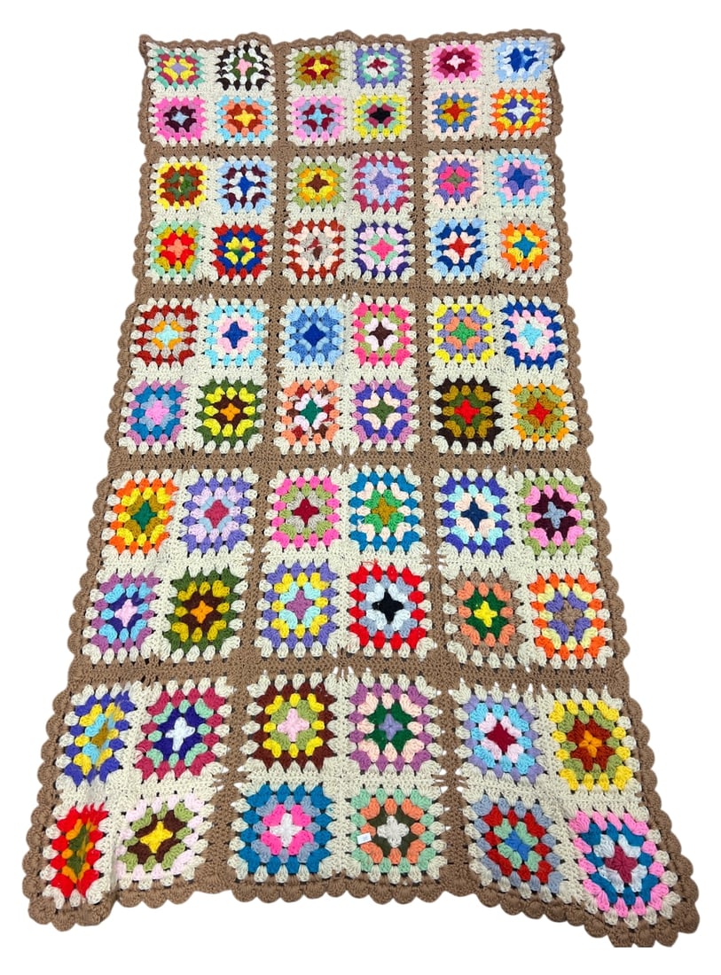 Handmade Granny Square Crochet Afghan 71x35: Handmade granny square crochet afghan blanket. Features multi-colored yarn squares with cream centers, joined by brown yarn borders with a scalloped edge. Measures 71 x 35 inches. Unmarked. Shows