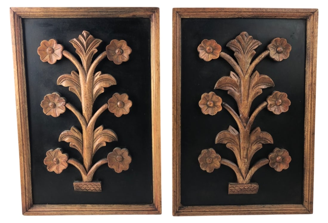 Mid Century Style Carved Wood Floral Wall Plaques: Pair of Mid Century style carved wood floral wall plaques. Features high relief stylized botanical motifs with six-petaled flowers on a black painted background, set within wooden frames. Unmarked. Sa