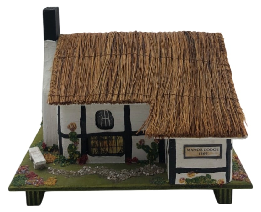 Pauline A. Ralph Manor Lodge 1560 Music Box: Handcrafted miniature Tudor house music and trinket box by Pauline A. Ralph, made in England. Features a thatched roof that opens to a felt-lined compartment. Plays "Waltz of the Flowers" via a Swiss 