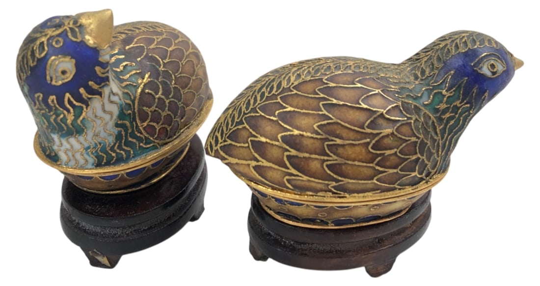 Pair of Chinese Cloisonné Bird Trinket Boxes: Pair of Chinese cloisonné enamel trinket boxes modeled as quails. Features intricate wirework with blue, green, and brown enamel plumage, and bright blue enameled interiors. Includes fitted dark wood