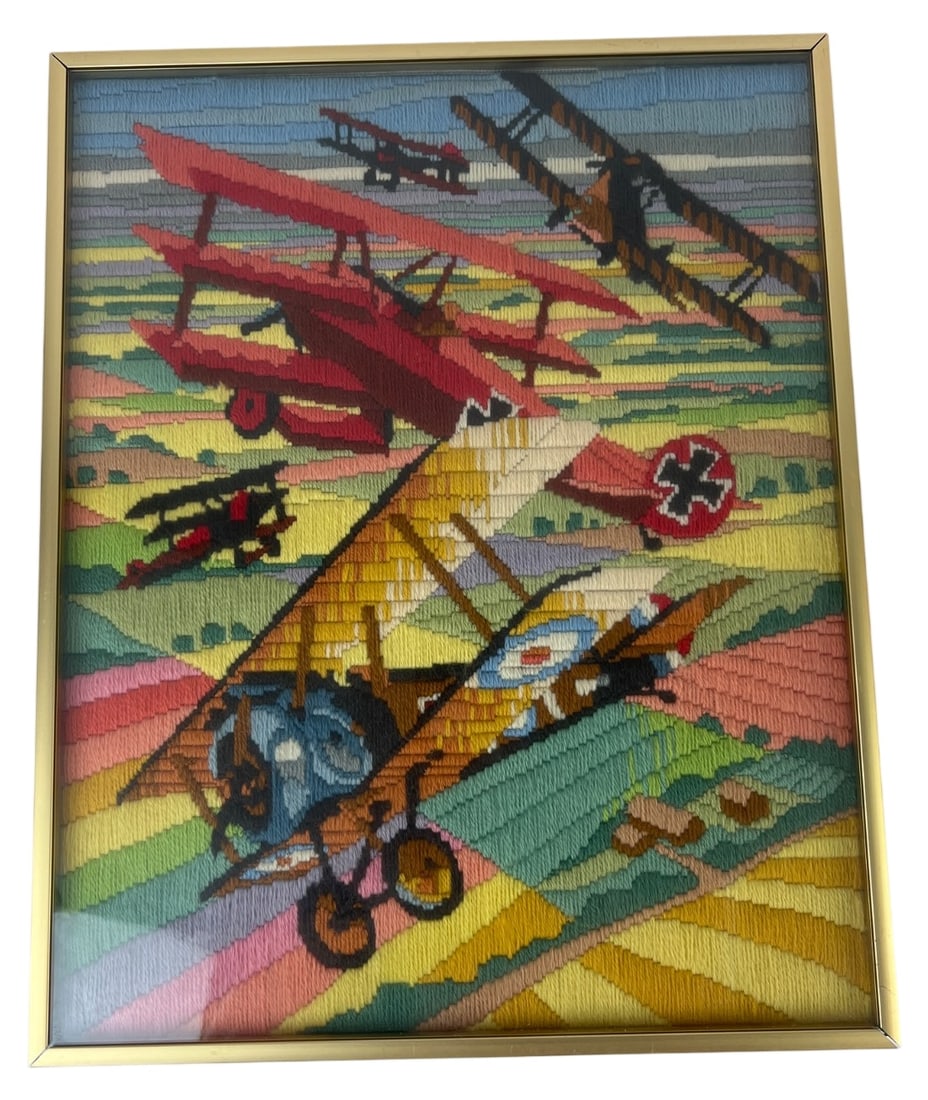 1982 Horizons Designs WWI Aviation Needlepoint: Framed long stitch needlepoint artwork depicting a WWI aerial dogfight with biplanes and a red triplane. Stamped "© 1982 Horizons" on the canvas edge. Worked in colorful yarn on canvas. Housed in a