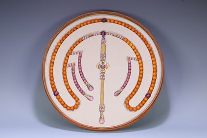 A PLATE OF OLD BEESWAX WITH RUBY BEADS
