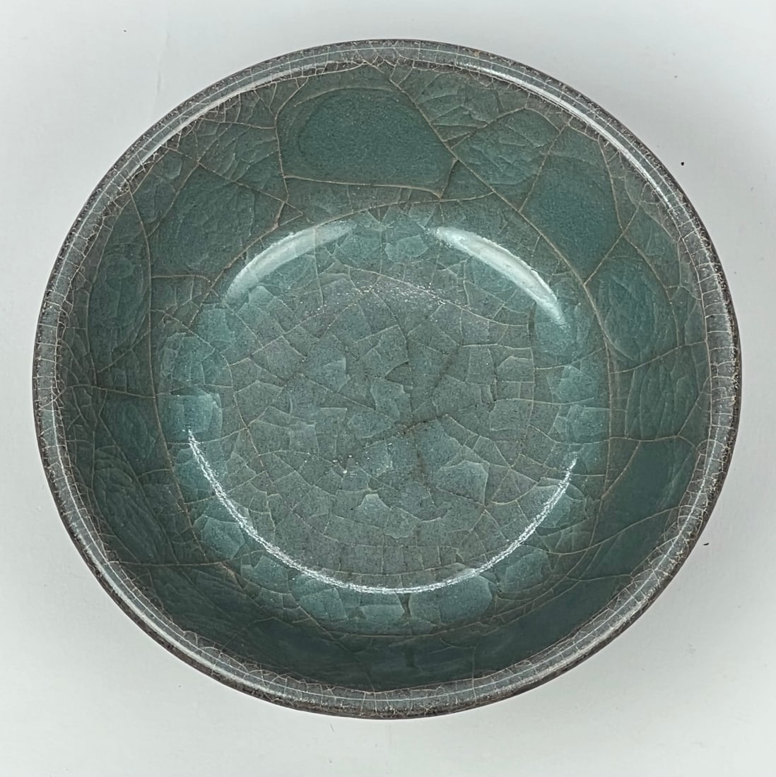 Song (14th C) Longquan Kiln Celadon Bowl (Black Body): A black-body celadon-glazed bowl, Longquan kiln, Song dynasty, of compact and well-balanced form.The glaze is rich green with natural crackle patterns, while the exposed foot reveals a dark body, char