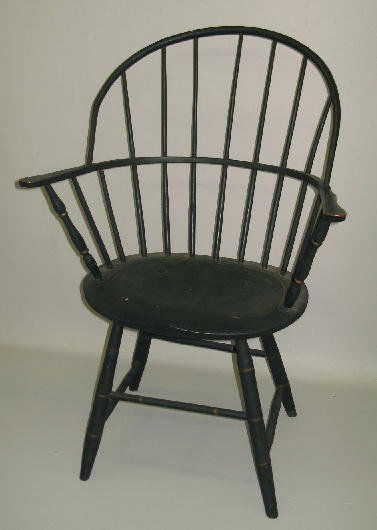 FOLKY SACK-BACK WINDSOR ARMCHAIR. Old dark green w: FOLKY SACK-BACK WINDSOR ARMCHAIR. Old dark green with gold striping. Seven tapered spindles pierce the arm rail with vase turned posts. Peaked seat with incised line. Bamboo turned legs with box stret