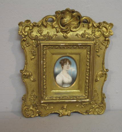 MINIATURE ON IVORY.: European, early 19th Century. Portrait of a young woman with finely curled hair, dressed in a white Empire dress. Blue background resembles clouds. Edinburgh framer's label "John Taylor, Joiner, Cabin