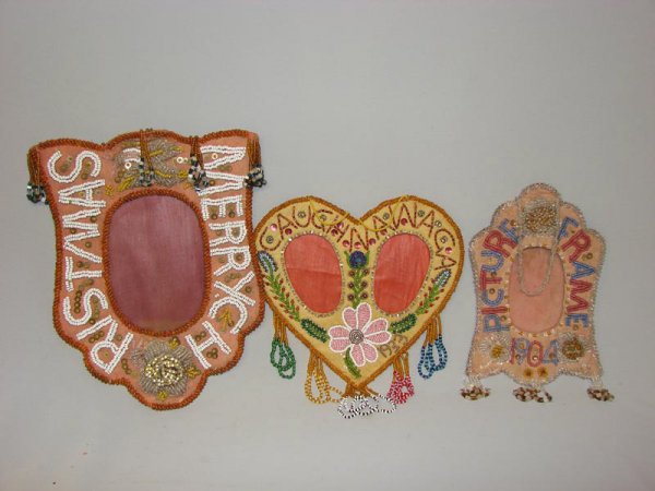 THREE IROQUOIS BEADED FRAMES. All three are fine,: THREE IROQUOIS BEADED FRAMES. All three are fine, folky examples. First has Merry Christmas" beaded around the opening. 11" h., 9" w. Second has "Picture Frame 1904" beaded in red and blue on a white
