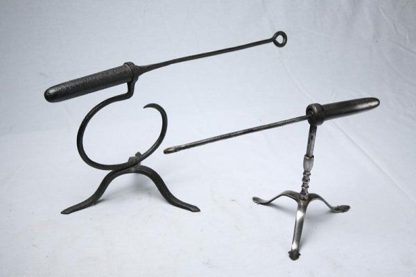 THREE PIECES OF WROUGHT IRON. Two goffering irons: THREE PIECES OF WROUGHT IRON. Two goffering irons with tripod bases. One has round pedestal. Largest 10"h. 19"l. Smaller 9"h. 14"l. Rush light holder with tripod base. 34 1/2"h.