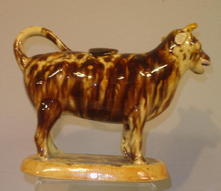 FLINT ENAMEL COW CREAMER. Yellowware with brown mo