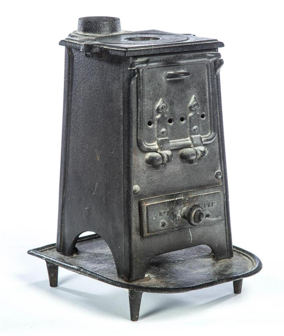 SMALL CAST IRON STOVE.: SMALL CAST IRON STOVE. American, mid 19th century. Canted sides, single lid top, hinged door, ash tray, separate base and embossed No. 2 6151P. 16"h. 10" w. 12.5"d.