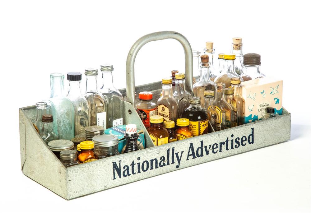 WATKINS TOTE AND PRODUCT BOTTLES.: WATKINS TOTE AND PRODUCT BOTTLES. American, 20th century. Steel handled tote, marked "Nationally Advertised" and "Watkins Products," 11.5"h. 24"l. 7.75"w. Numerous Watkins product bottles and containe