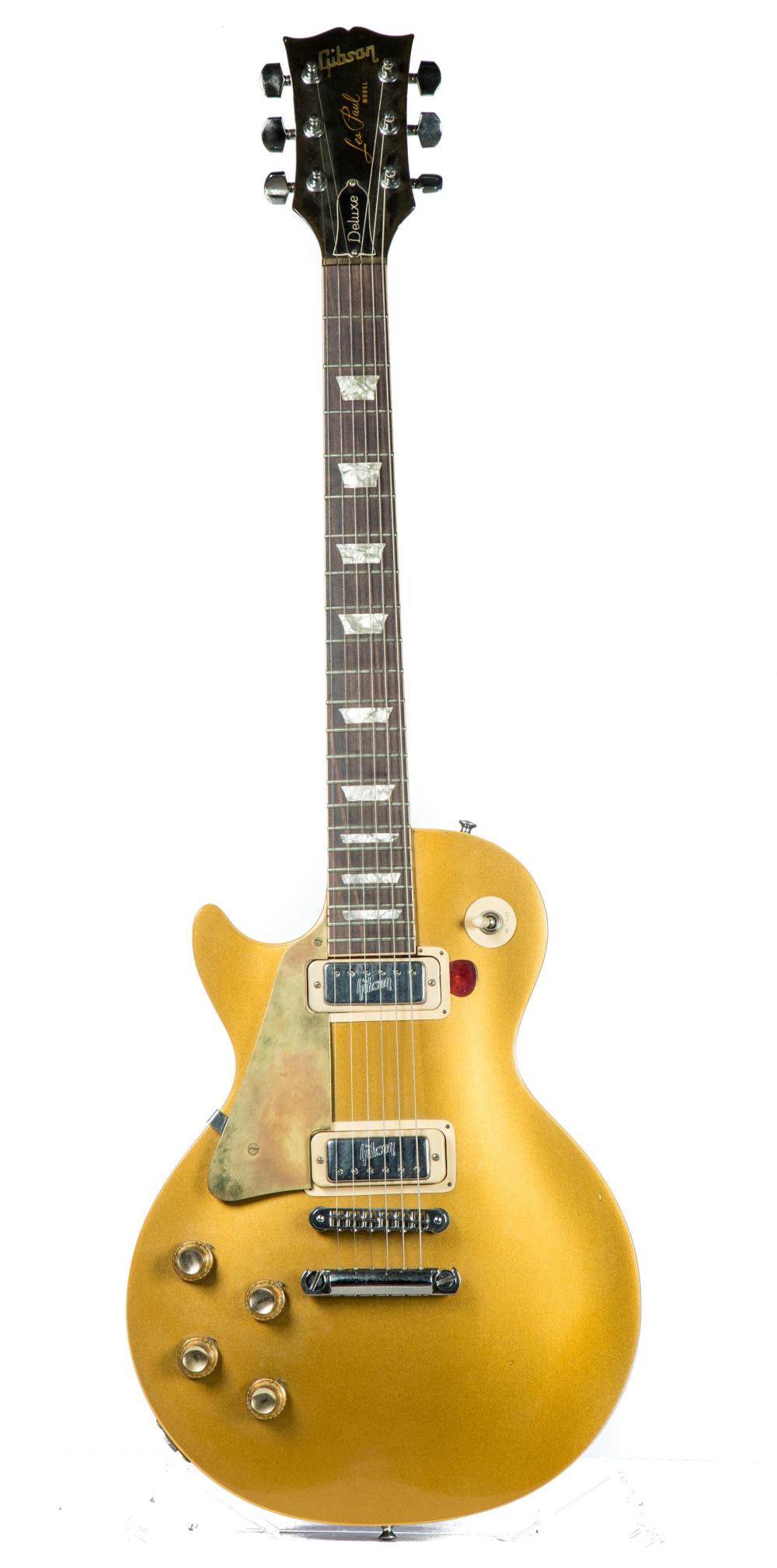 GIBSON LES PAUL DELUXE LEFT HANDED GOLD TOP GUITAR.: GIBSON LES PAUL DELUXE LEFT HANDED GOLD TOP GUITAR. American, 1970-72. Tuners have been replaced at some point and are marked "Made In W. Germany", serial number 612823.