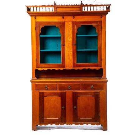 COUNTRY VICTORIAN TWO PIECE STEPBACK CUPBOARD.: American. 3rd quarter-19th century. Ash and walnut with pine secondary, cornice with turned spindles, sawtooth trim and turned finials, ogee molding, two single pane glass doors, chamfered corners, pi