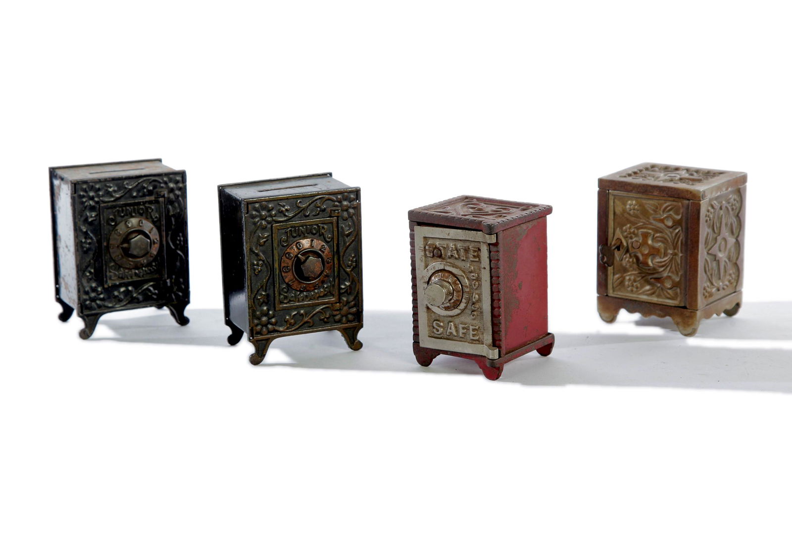 FOUR CAST IRON SAFE BANKS.: American, 4th quarter 19th Century. Two are "Junior Safe Deposit", 4.5"h. 3.25"w. 2.25"d.; "State Safe" 4"h. 2.75"w. 3"d. and J & E Stevens "Key Lock Safe No 50". 4"h. 3.25"w. 2.75"d.