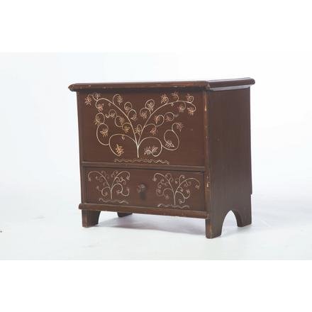 ELDRED WHEELER PAINT DECORATED CHEST.: American. Late 20th century. Pine with routed edge on lid, dovetailed drawer, bootjack ends, brown base paint and red and white floral decoration, 20.5"h. 22.5"w. 13"d.