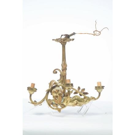 FIRE GILDED BRASS CHANDELIER.: American. 20th century. Central flying cherub surrounded by foliage and four light branches, rolled drapery stem and ribbon cap, 14.5"h. 17"w. 10.5"d.