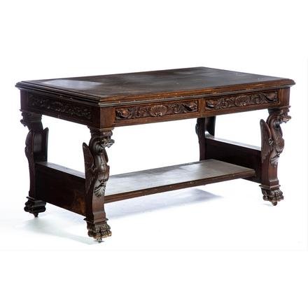 LABELED STEUL AND THURMAN LIBRARY TABLE.: American. Buffalo, New York. Mahogany with old alligatored finish, top with routed edge, two dovetailed drawers, case with applied carvings on all four sides, ends with carved griffins having chest sh