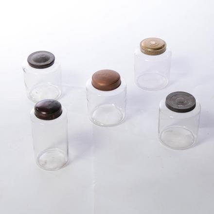 FIVE CLEAR GLASS NON-FLINT CANISTER JARS,: American, 4th quarter, 19th Century. All have tin lids. One is a replaced screw top lid. 10"h and four are 7.5"h.