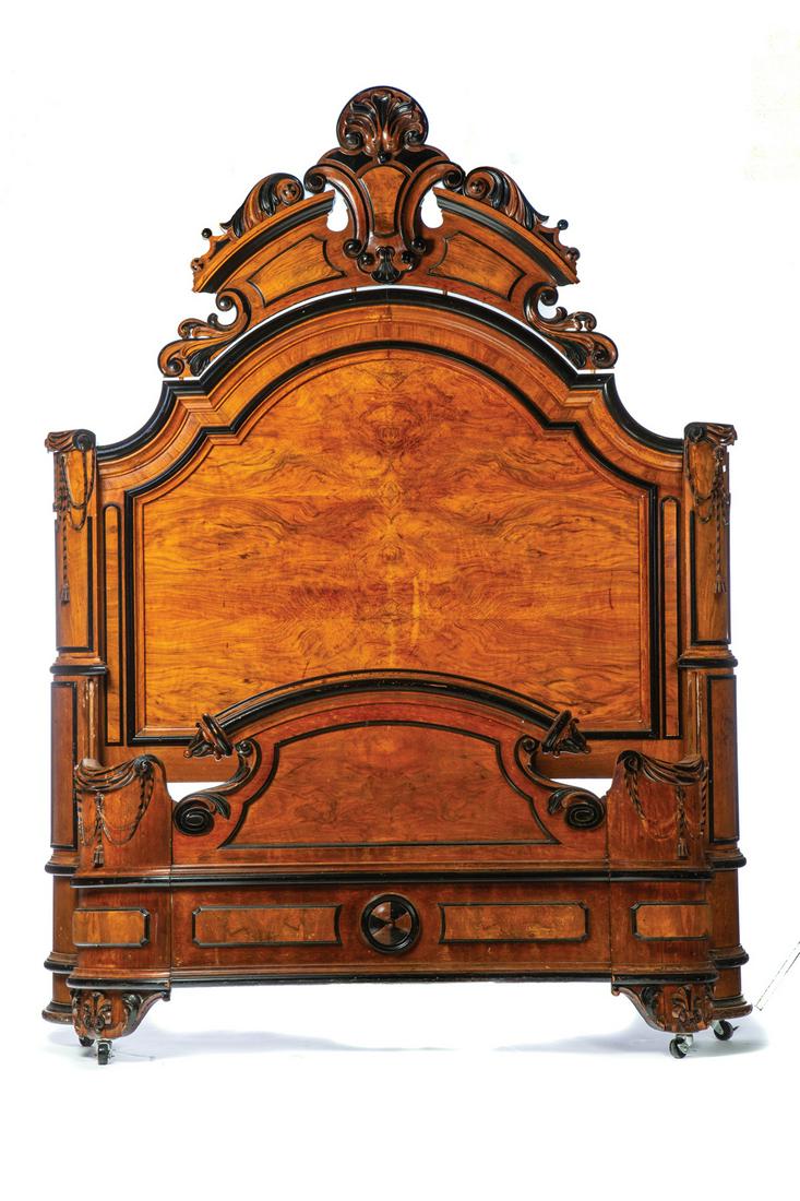 HIGH STYLE VICTORIAN BED.: American. 3rd quarter-19th century. Mahogany, pine with ebonized trim, headboard with heavily carved crest and center anthemion, rounded corners with drapery caps and cord and tassels trim, foot board