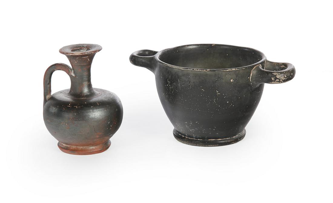 TWO GREEK BLACKWARE POTTERY PIECES.: Apulia, Italy, ca 4th century BC. Redware pottery with remaining black glaze (slightly iridescent). Double handled bowl, 3”h. And a small jug or ewer with applied handle, 3.5”h. Wear and some flak