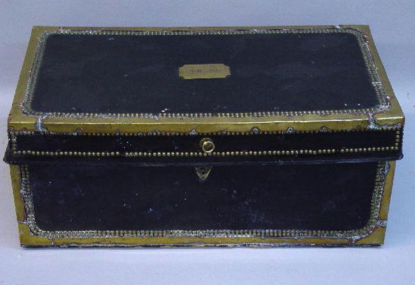 ORIENTAL EXPORT TRUNK. Black leather cov: ORIENTAL EXPORT TRUNK. Black leather coverings with brass bindings and tacks. Camphor wood. Engraved brass plate on the lid "M. W. Allen". Interior is lined with an old wallpaper with gold flowers. To