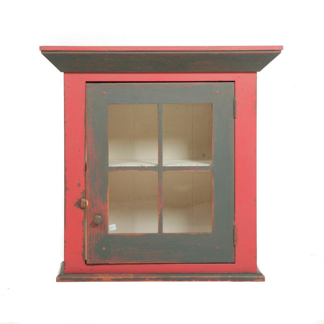 DAVID T. SMITH HANGING CUPBOARD.: Ohio, late 20th century, poplar. Beveled cornice, four-pane door, spoon cutouts on interior shelf. Distressed red and black paint with stenciled label on back. 26.75"h. 27.25"w. 11.75"d.