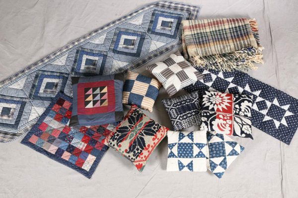 TWELVE TEXTILES. Eight pillows made from quilts a: TWELVE TEXTILES. Eight pillows made from quilts and coverlets. Two quilted table runners. Doll size quilt. Coverlet throw in mustard, green, blue, red and ecru. 68"l. 52"w.