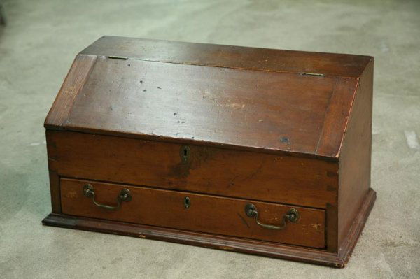 PINE TABLE TOP DESK. Pine with a lift lid and on: PINE TABLE TOP DESK. Pine with a lift lid and one lower drawer. Interior is fitted with pigeon holes and five small drawers. Dovetailed case and ogee molding around base. Partial label inside drawer r