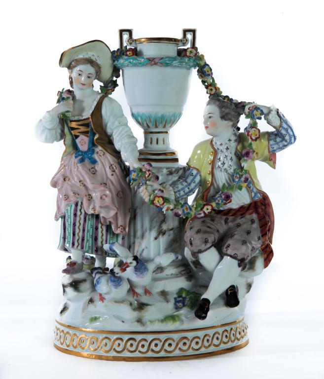 MEISSEN FIGURAL GROUP.: German late 19th century. A couple and young girl in 18th century style clothing surrounding a fluted column with urn, garlands of flowers and two birds at couples feet on a base with gold banded deco