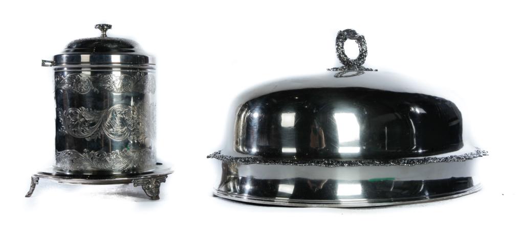 TWO SILVERPLATED SERVING PIECES.: England. A mid 19th century dome with tinned interior, foliate handles and border, and inlaid sterling block for engraving. 9"h. And a 20th century biscuit jar with engraving and attached under plate 