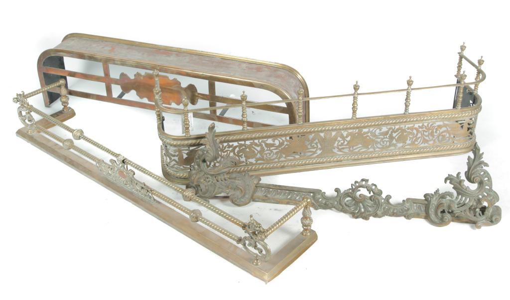 FOUR BRASS AND STEEL FIRE FENDERS.: European, 19th century. Very plain with kettle stand top, 7"h. 47.5"w. 12.5"d. Heavily cast foliage, 10.75"h. 44"w. Open work with mythical animal, cherubs, and foliage, and gallery top, 14.75"h. 50"w