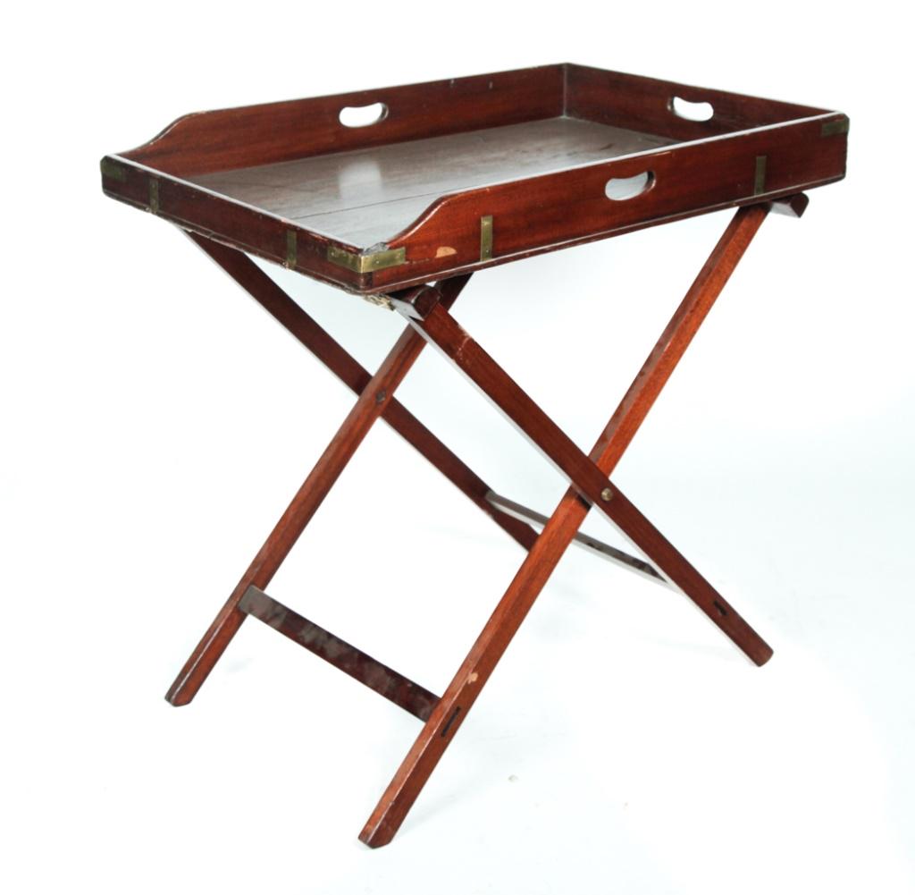 BUTLERS TRAY AND STAND.: England, mid 19th century. Mahogany, dovetailed tray with hand grips and brass corners and stand with mortised construction. Edgewear. 33"h. 22"w. 33"d.
