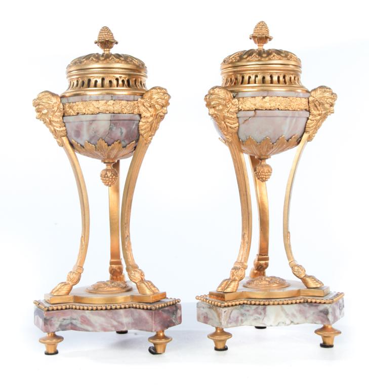 PAIR OF GILDED BRONZE AND MARBLE URNS.: European, ca. 1900. Pink marble bowls, bronze mounts with Classical detail, pinecone finials and chop finials, Bacchus heads and hoof feet on legs, tri foil bases with turned feet. Marble bowls have r