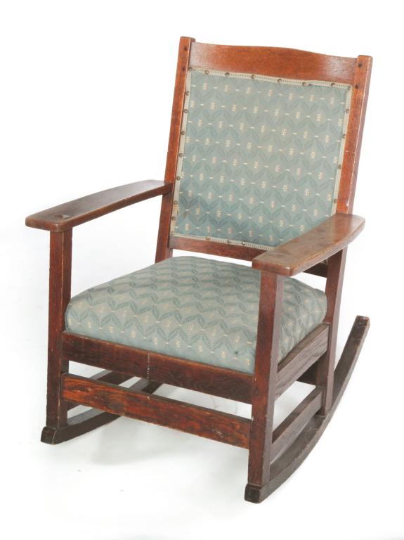 MISSION ROCKER BY TAYLOR.: Bedford, Ohio. 1st quarter 20th century. Quarter sawn oak, older finish, upholstered back and seat and decal label on back of seat. 17" seat ht. 33.5"h.