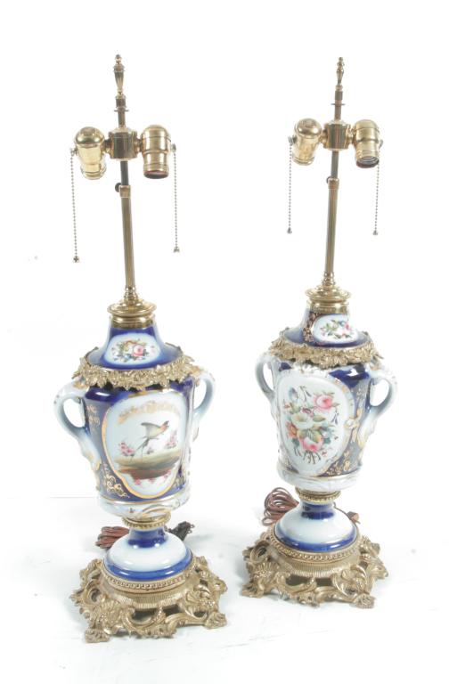 PAIR OF OLD PARIS URN TABLE LAMPS.: France, 2nd half 19th century. White porcelain with cobalt fields, Dresden flower and bird reserves, gold trim, and heavy brass ormolu mounts. 30"h.
