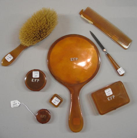 EIGHT-PIECE DRESSER SET. Two smallest pieces are t: EIGHT-PIECE DRESSER SET. Two smallest pieces are tortoise shell, the rest are probably amber. Mirror, 11 7/8"l., brush, 8 3/4"l., comb, nail file, compact, pill box and two boxes. Four pieces have dia