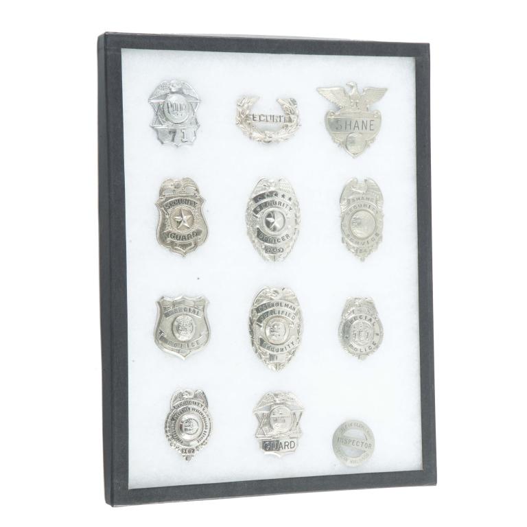 RIKER MOUNT OF MAINLY SECURITY BADGES: RIKER MOUNT OF MAINLY SECURITY BADGES. American, 20th century. Three hat badges, five security badges, and a City of Cleveland building inspector badge.