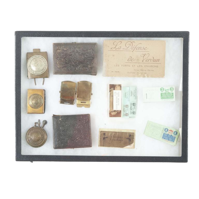 RIKER MOUNT WITH EUROPEAN AND AMERICAN MEMORABILIA: RIKER MOUNT INCLUDING EUROPEAN AND AMERICAN MEMORABILIA. Includes a "La Defense de Verdun” illustrated postcard book, two solid brass buckles, paper encased .58 caliber minie ball, Ohio sales tax ve