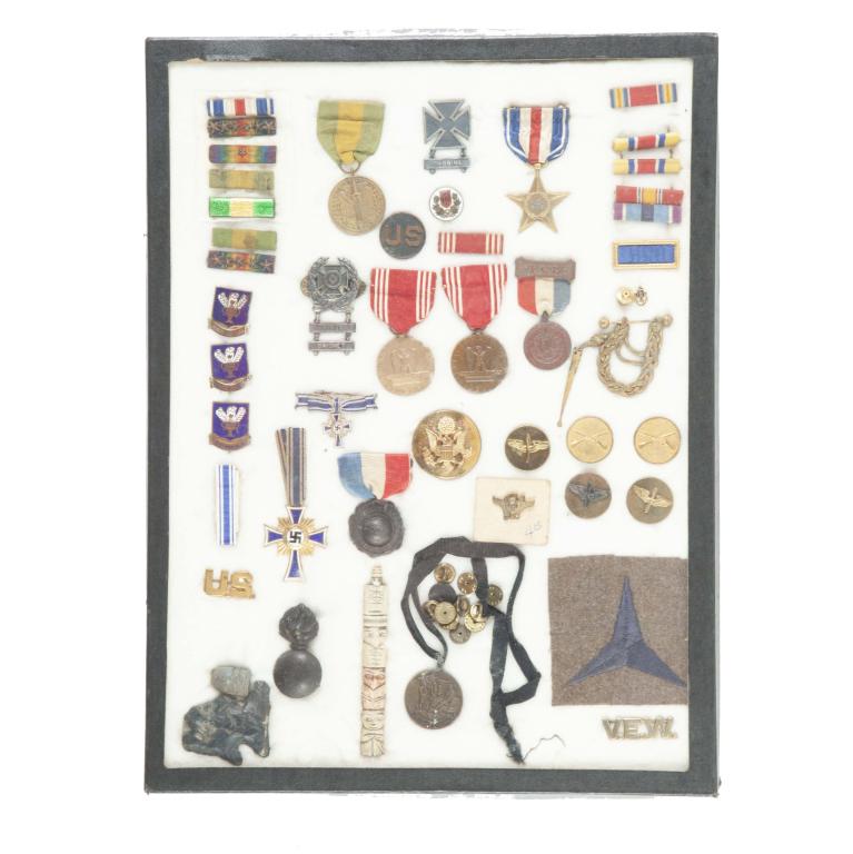 RIKER MOUNT OF MOSTLY PINS AND RIBBONS: RIKER MOUNT OF MOSTLY PINS AND RIBBONS. Grouping includes German WW2 medals, and American military pins. Does include a Native American relic, Civil War era bullet, and etc.