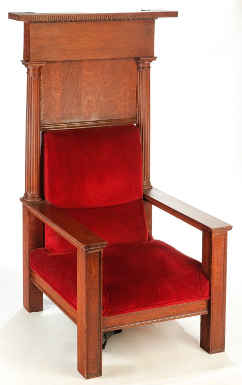 AMERICAN MASONIC ARMCHAIR.: Late 19th-early 20th century, oak. Massive chair with burgundy upholstery, fluted columns and removable crest with dentil and egg and dart molding. Alligatored varnish. 69"h. 40.25"w. 34.5"d.