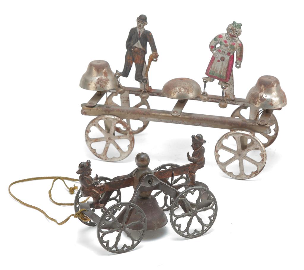 TWO BELL RINGER PULL TOYS.: American, ca. 1910. One triple bell pull toy with Mammy and Charlie Chaplin, along with a cast iron single bell pull toy depicting two boys on a seesaw. 6.5"l and 10"l.