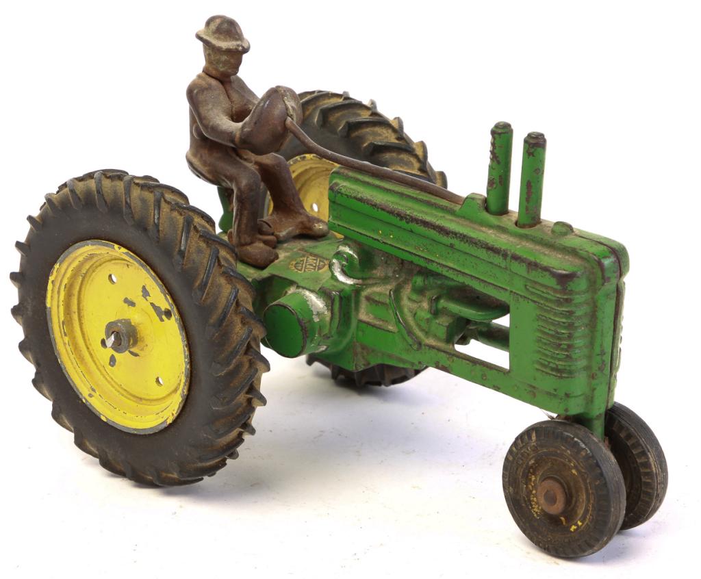 ARCADE MANUFACTURING TOY TRACTOR.: American, 2nd quarter-20th century. Cast iron with green paint, yellow wheels, black rubber tires, and driver, 5.25"h.