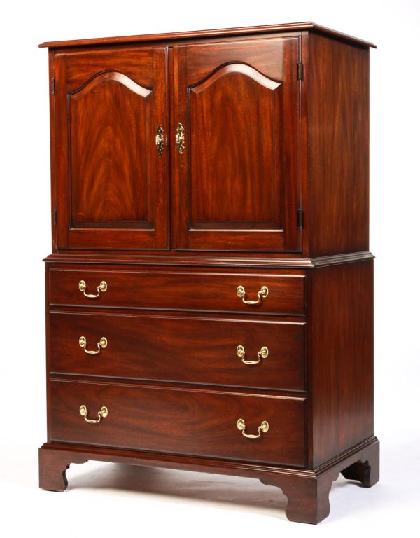 AMERICAN CHIPPENDALE STYLE LINEN PRESS.: Made by Henkel Harris, late 20th century, mahogany with oak secondary. Top with routed edge, two arched raised panel doors, three overlapping dovetailed drawers, solid ends and bracket feet. 55.5"h. 3