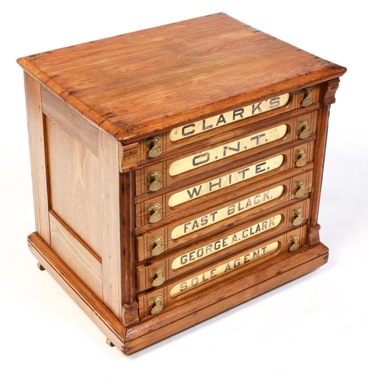 AMERICAN O.N.T. SPOOL CABINET.: Fourth quarter 19th century, ash with pine secondary. Eastlake Victorian details, six drawers with finger joints, brass "ONT" pulls and gold reverse painted labels with worn black lettering. 23.5"H. 2