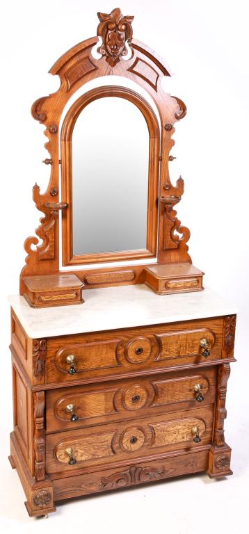 AMERICAN HIGH STYLE VICTORIAN DRESSER.: Third quarter 19th century, ash with walnut trim and pine secondary. White marble top. Mirror frame with carved anthemion and grape carved crest, candle stands and glove boxes, base with four dovetail