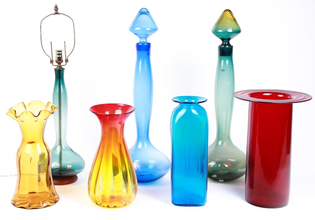SEVEN LARGE PIECES OF AMERICAN BLENKO GLASS.: Second half 20th century. Two stoppered bottles, green and amber, 31"h. and blue, 31.5"h., smoky blue table lamp, 32"h., ruby stove pipe hat shape, 17.5"h., rectangular blue with ribbing, 17"., amber 