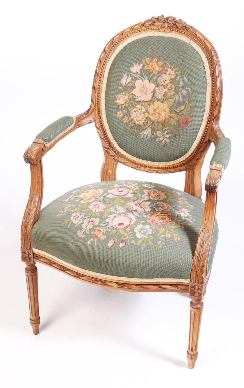 EUROPEAN LOUIS XVI STYLE BERGERE.: Ca. 1900, mahogany. Foliate carved frame, turned fluted legs and floral needlework back and seat. 18" seat, 37"h.