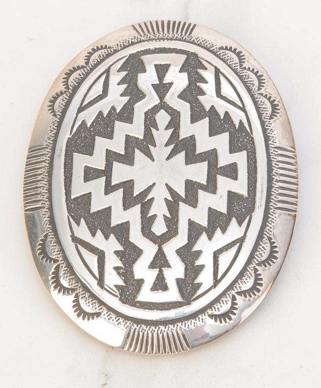 THOMAS SINGER STERLING NAVAJO BELT BUCKLE.: American, late 20th century. Large oval sterling silver belt buckle with traditional Navajo design, signed T. Singer, marked Sterling. Measures approx. 3.5" x 2.5", weight 58gr.